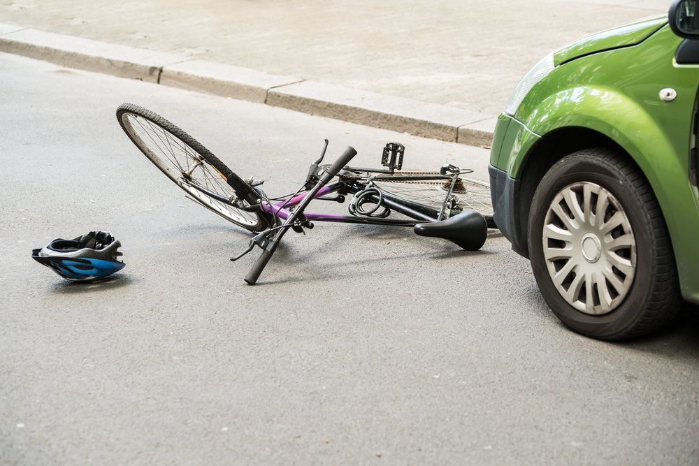 A bicycle lying in front of a car